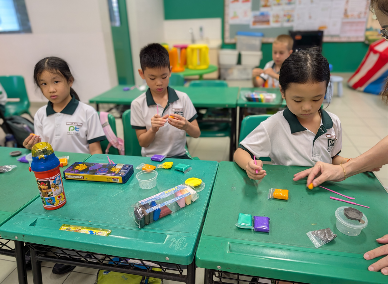 Students participating in a hands-on classroom art activity, creating and decorating lantern crafts together at their desks